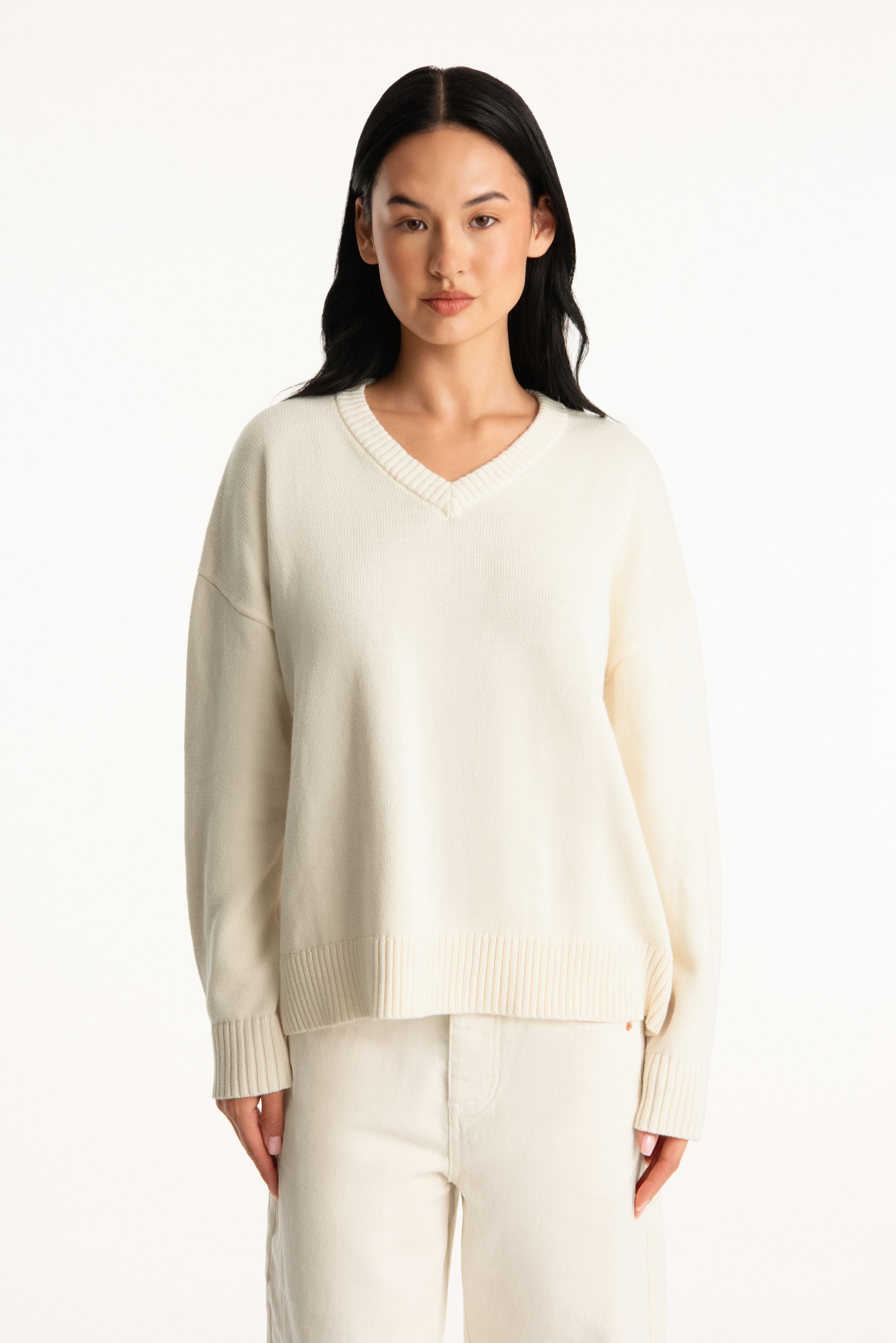 Woman wearing a beige sweater and pants on a white background <model-info>Jasmine wears a size S/M and is 5’8”, 25" waist, 36” bust.</model-info>