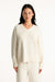 Woman wearing a beige sweater and pants on a white background <model-info>Jasmine wears a size S/M and is 5’8”, 25" waist, 36” bust.</model-info>