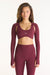 Woman wearing a maroon athletic outfit with long sleeves on a white background <model-info>Jana wears a size S and is 5’4½”, 24” waist, 33½” bust.</model-info>