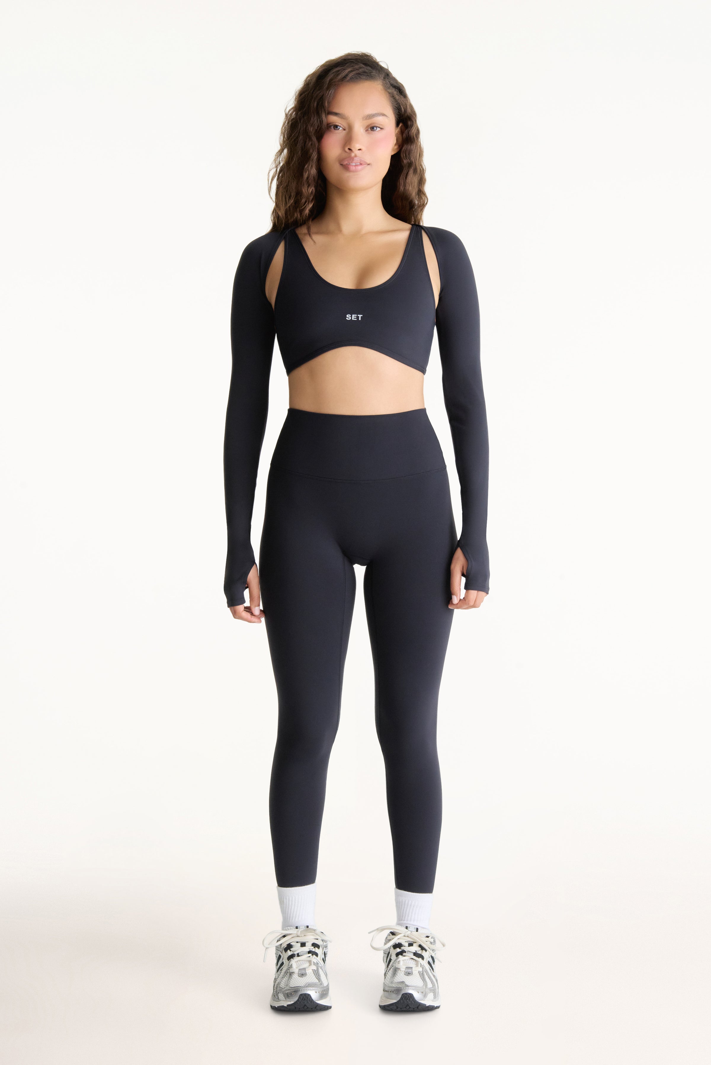 Woman wearing a black athletic outfit on a white background