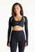 Woman wearing a black long-sleeve sports bra and leggings on a white background <model-info>Jana wears a size S and is 5’4½”, 24” waist, 33½” bust.</model-info>