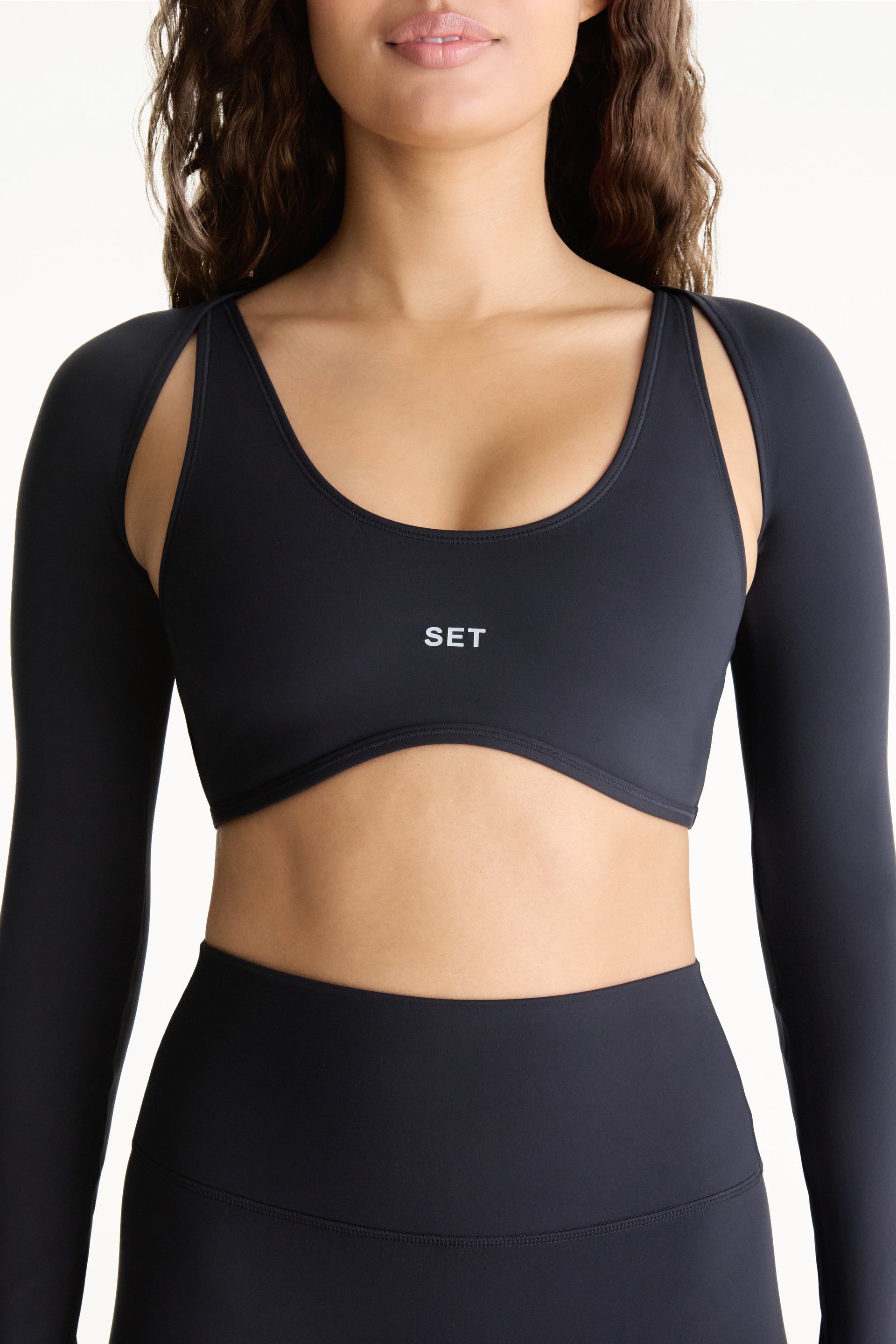Black sports bra and leggings with 'SET' branding on a white background