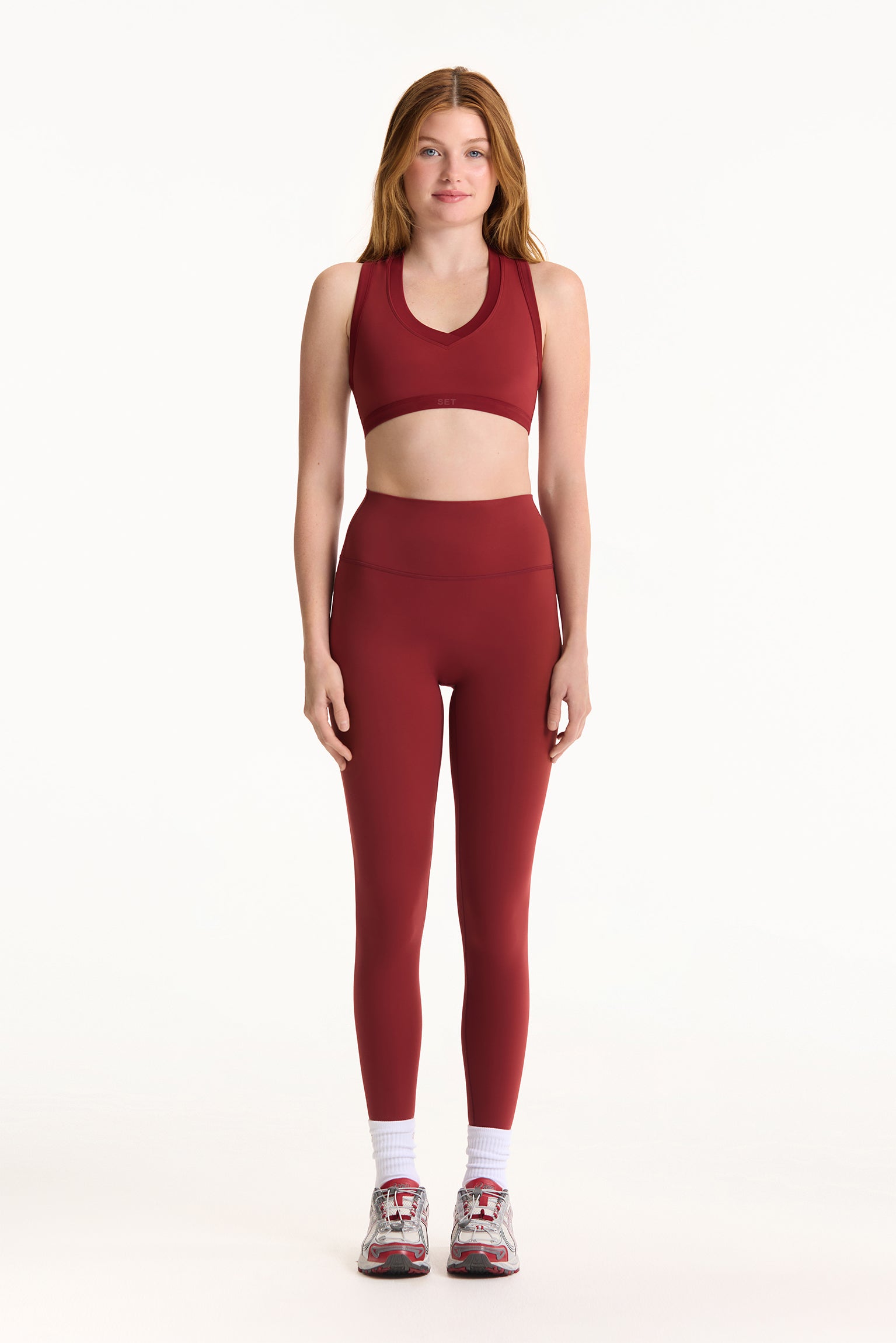 Woman wearing a red athletic outfit on a white background