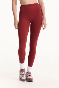 Red leggings worn by a person on a white background 