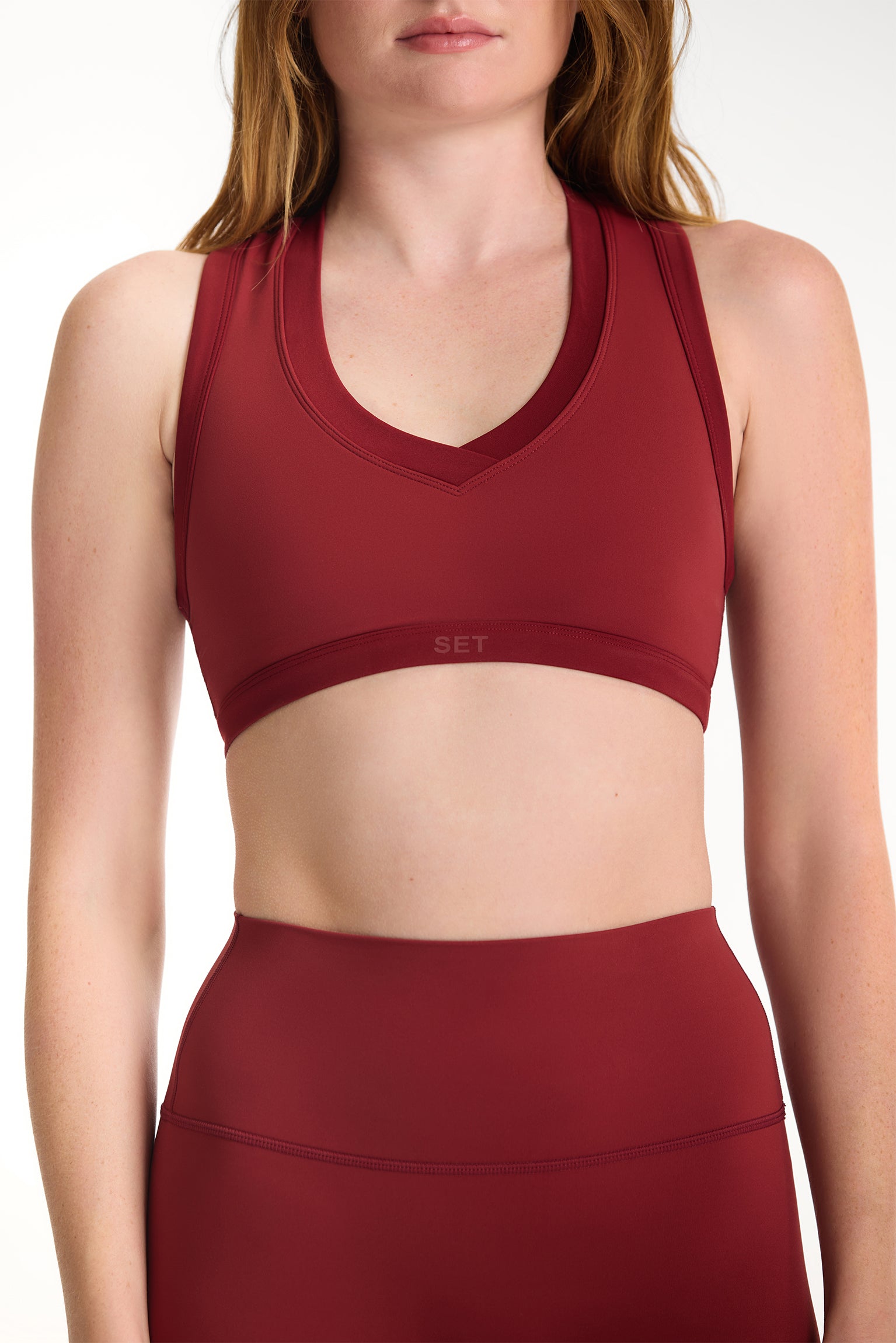Red sports bra and leggings on a plain background