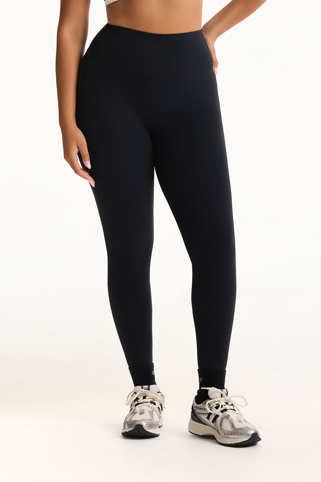 Person wearing black leggings on a white background <model-info>Jade wears a size L and is 5’9”, 30” waist, 38” bust.</model-info>