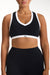 Black sports bra with white accents worn by a person on a white background