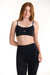 Woman wearing a black sports bra and leggings on a white background <model-info>Dickey wears a size S and is 5’9”, 24” waist, 32” bust.</model-info>