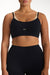 Person wearing a black sports bra and leggings with 'SET' branding.
