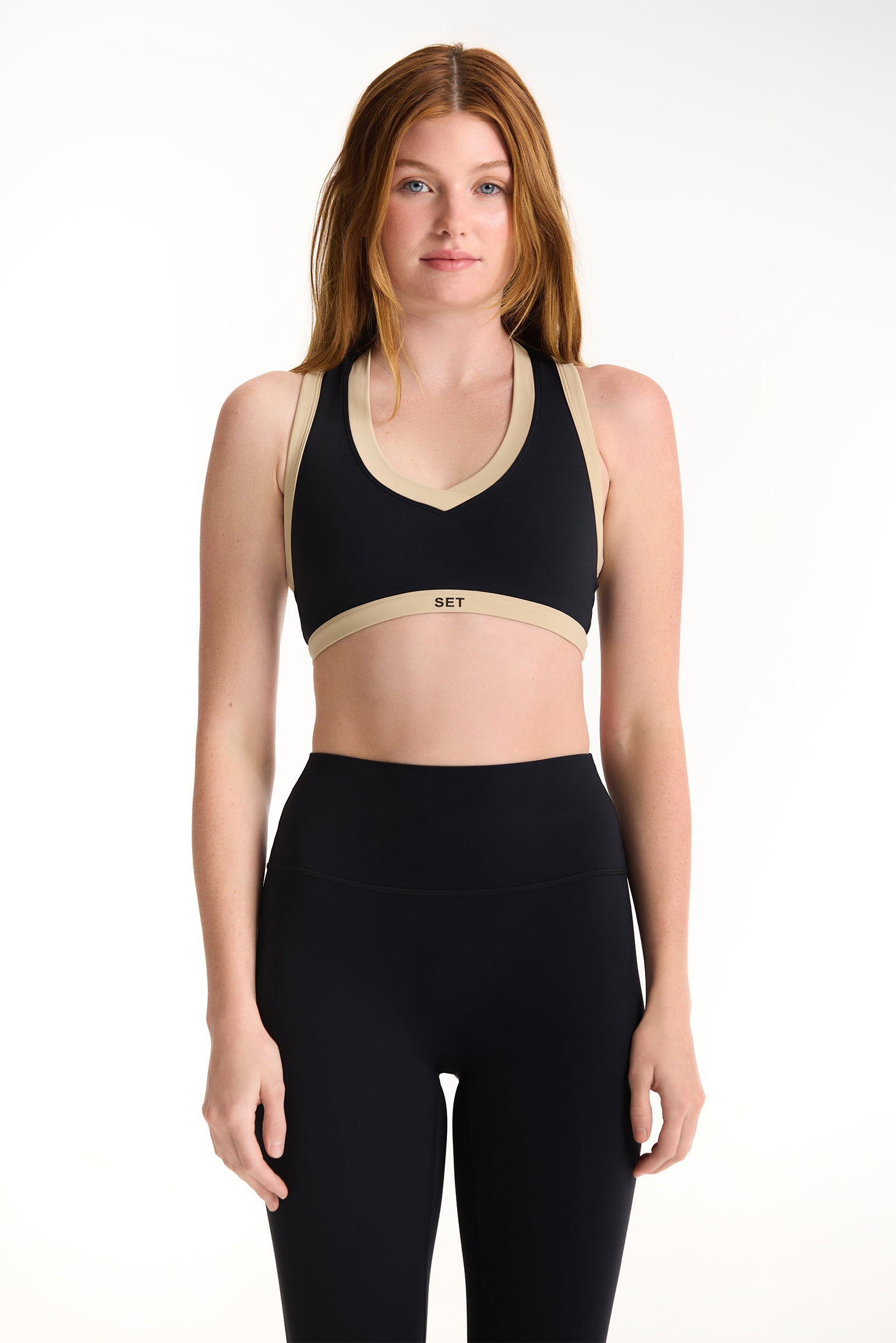Woman wearing a black sports bra and leggings on a white background <model-info>Dickey wears a size S and is 5’9”, 24” waist, 32” bust.</model-info>