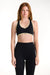 Woman wearing a black sports bra and leggings on a white background <model-info>Dickey wears a size S and is 5’9”, 24” waist, 32” bust.</model-info>