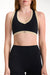 Black sports bra with beige accents worn by a person on a white background