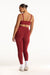 Person wearing a red sports bra and leggings set on a white background