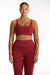 Woman wearing a red sports bra and leggings set on a white background <model-info>Jade wears a size L and is 5’9”, 30” waist, 38” bust.</model-info>