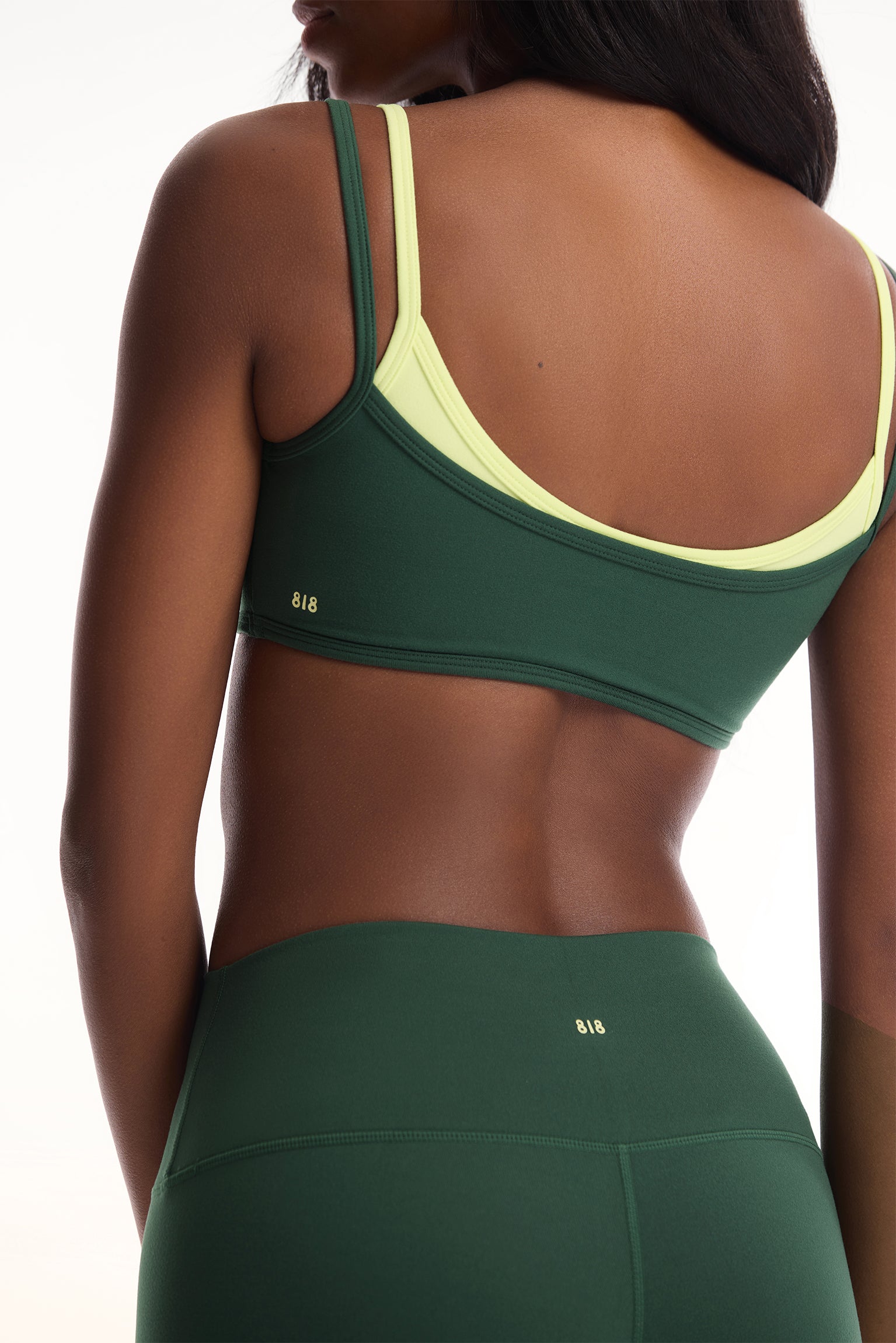 Green sports bra and leggings set on a white background