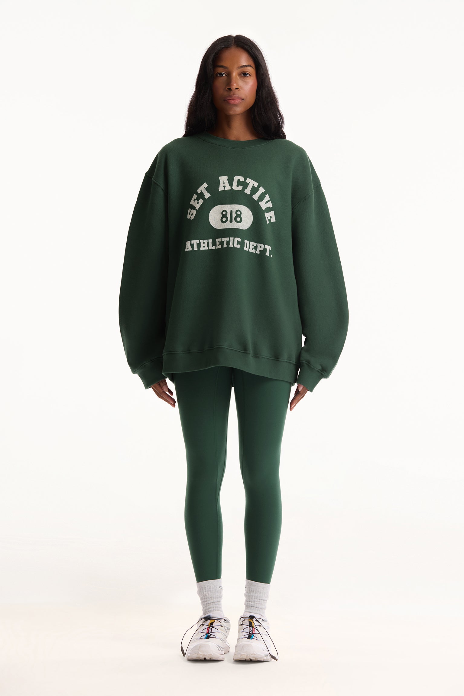 Person wearing a green sweatshirt and green leggings with text on a white background