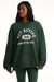 Woman wearing a green sweatshirt with 'SET ACTIVE' text on a white background <model-info>Autumn wears a size S and is 5’7½“, 25" waist, 32" bust.</model-info>