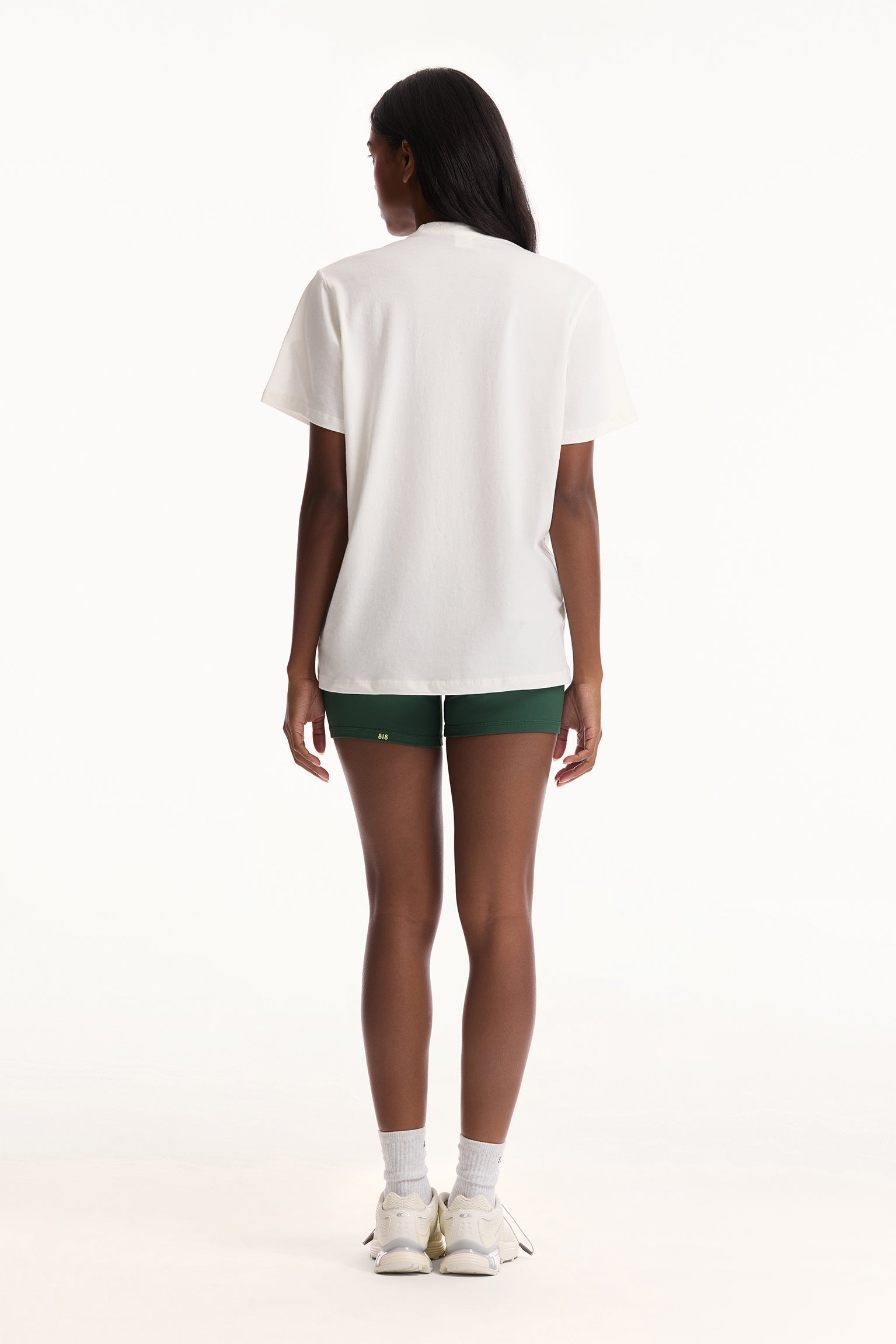 Person wearing a white t-shirt and green shorts on a white background