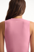 Pink sleeveless top worn by a person on a white background