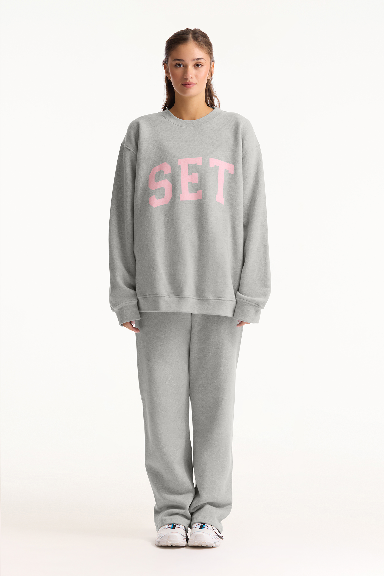 Person wearing a gray sweatshirt with 'SET' printed in pink on a white background