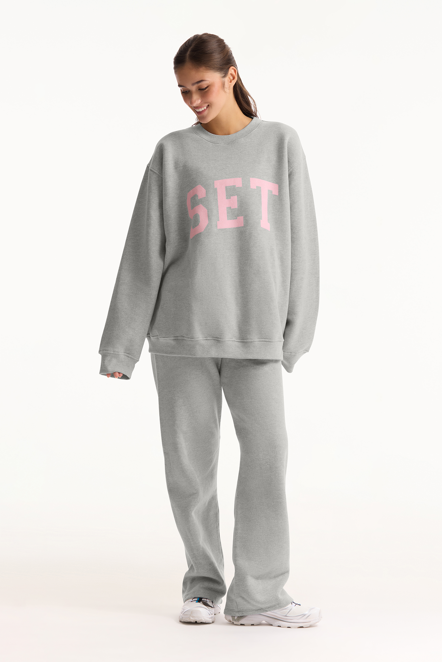 Person wearing a gray sweatshirt with 'SET' printed in pink on a white background