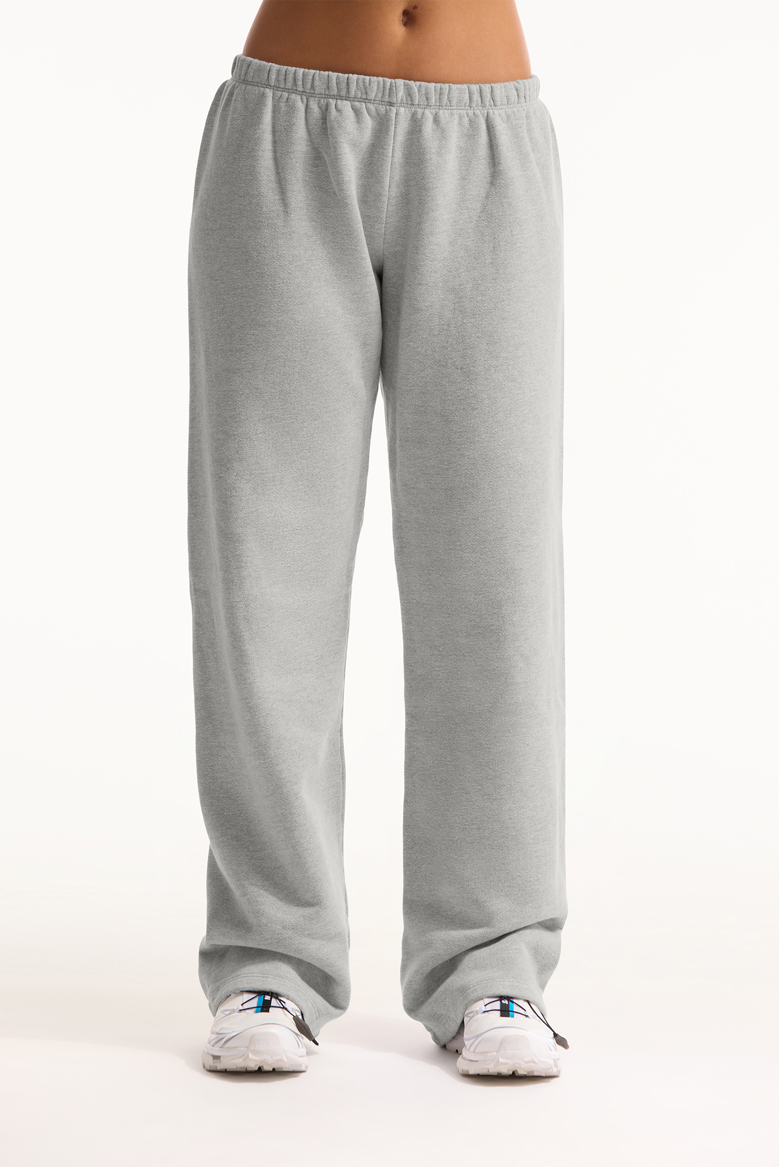 Gray sweatpants worn by a person on a white background 