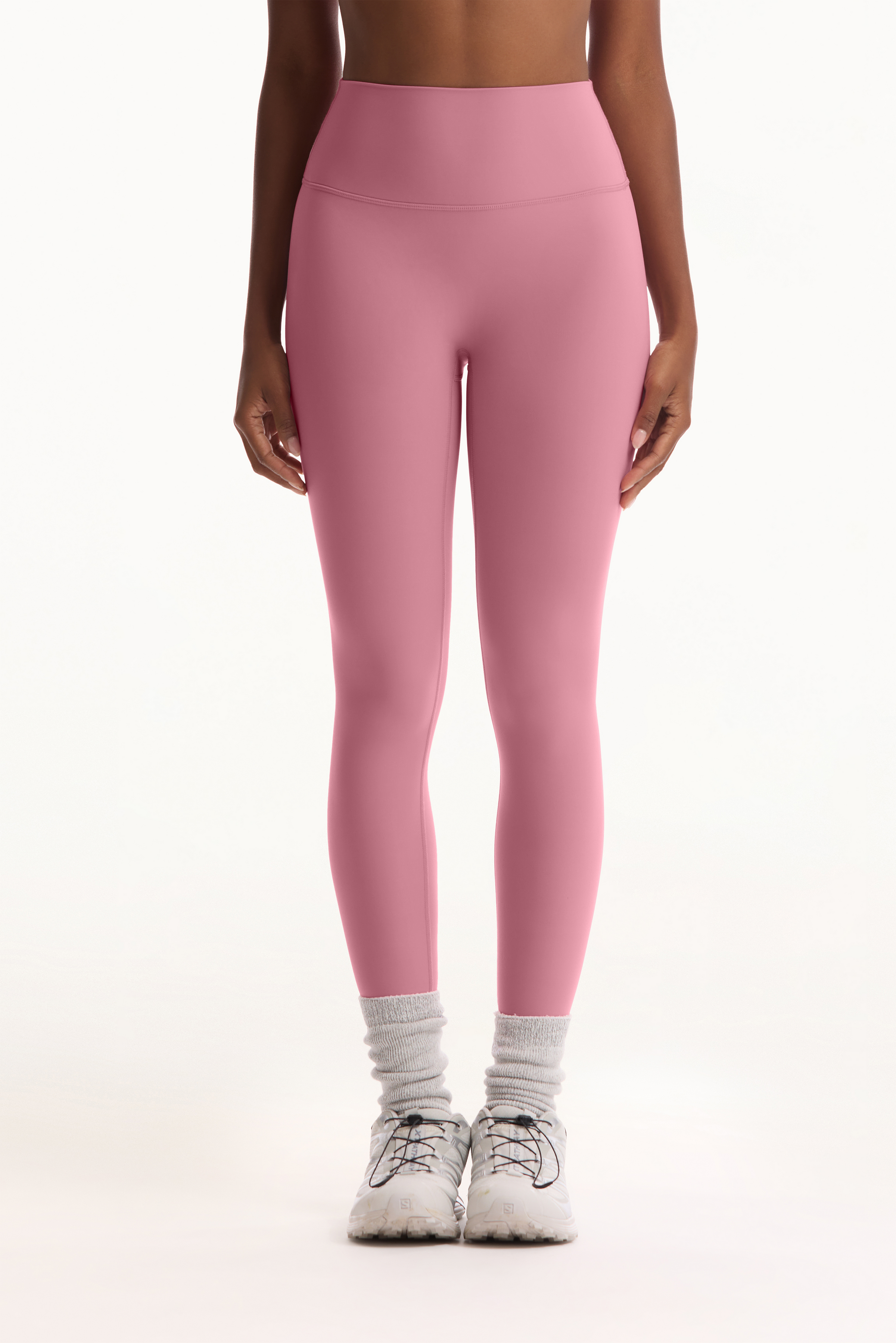 Person wearing pink leggings on a white background 