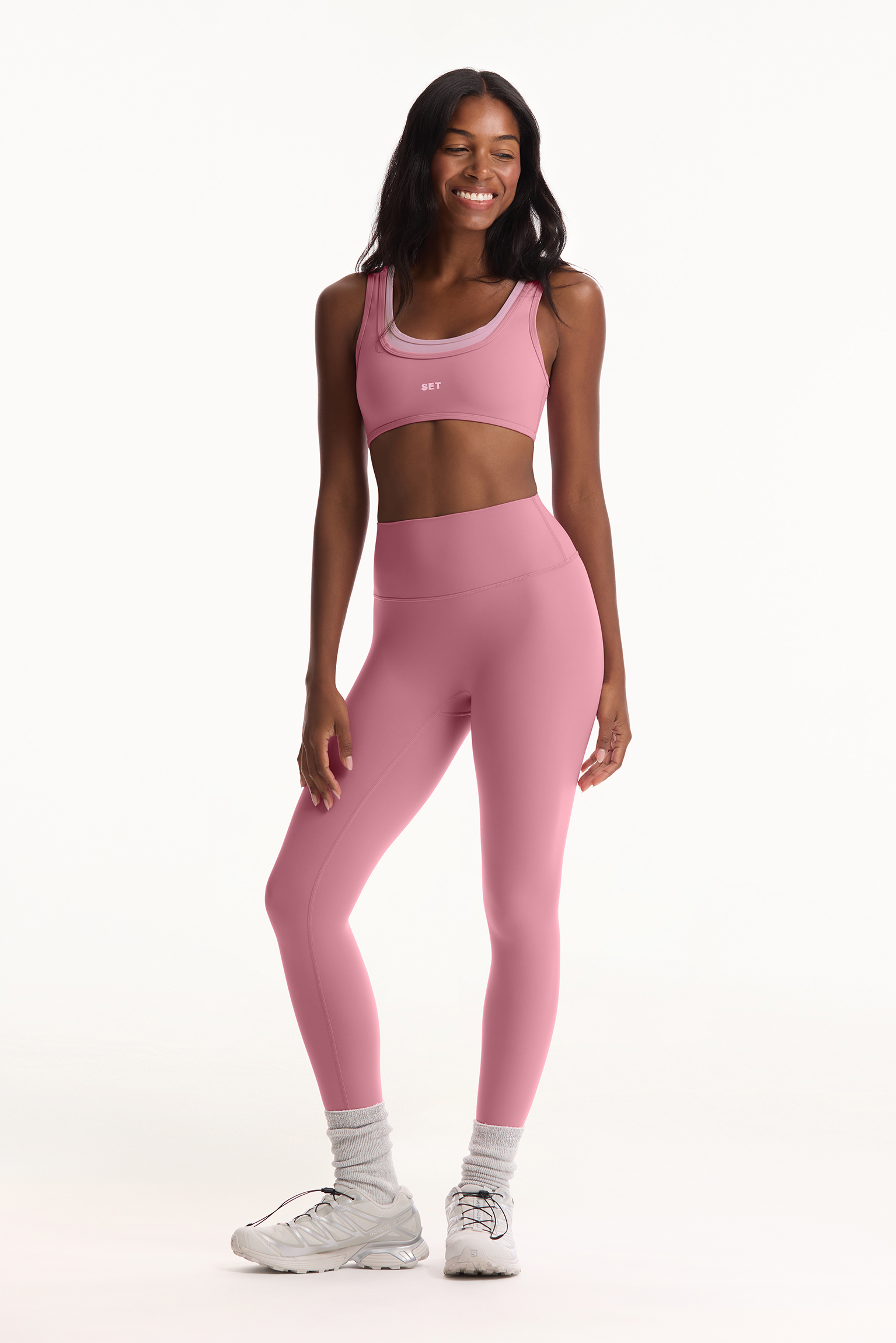 Woman wearing a pink athletic outfit on a white background