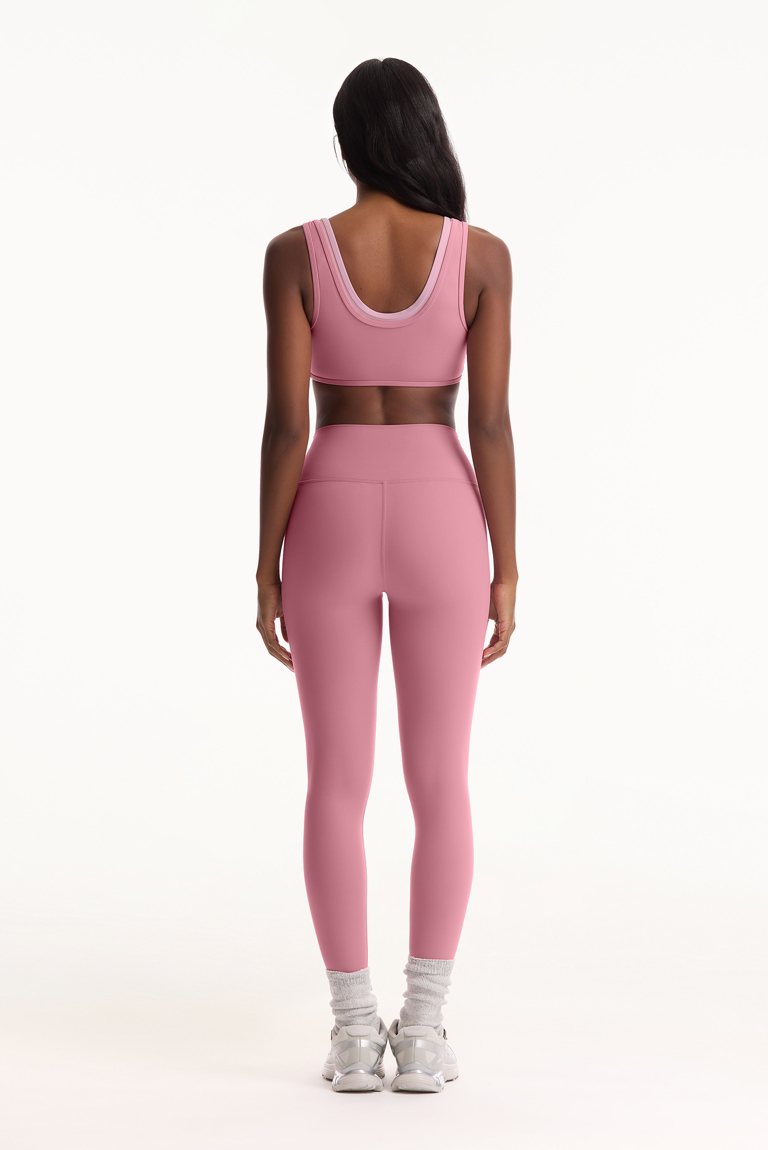 Person wearing a pink athletic outfit on a white background