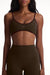 Woman wearing an olive green sports bra and leggings set on a white background