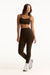 Woman wearing a black sports bra and leggings on a white background
