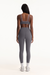 Person wearing a gray sports bra and leggings set on a white background