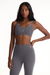 Woman wearing a gray sports bra and leggings set on a white background <model-info>Autumn wears a size S and is 5’7½”, 25” waist, 32” bust.</model-info>