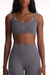 Woman wearing a gray sports bra and leggings with 'SET' branding.
