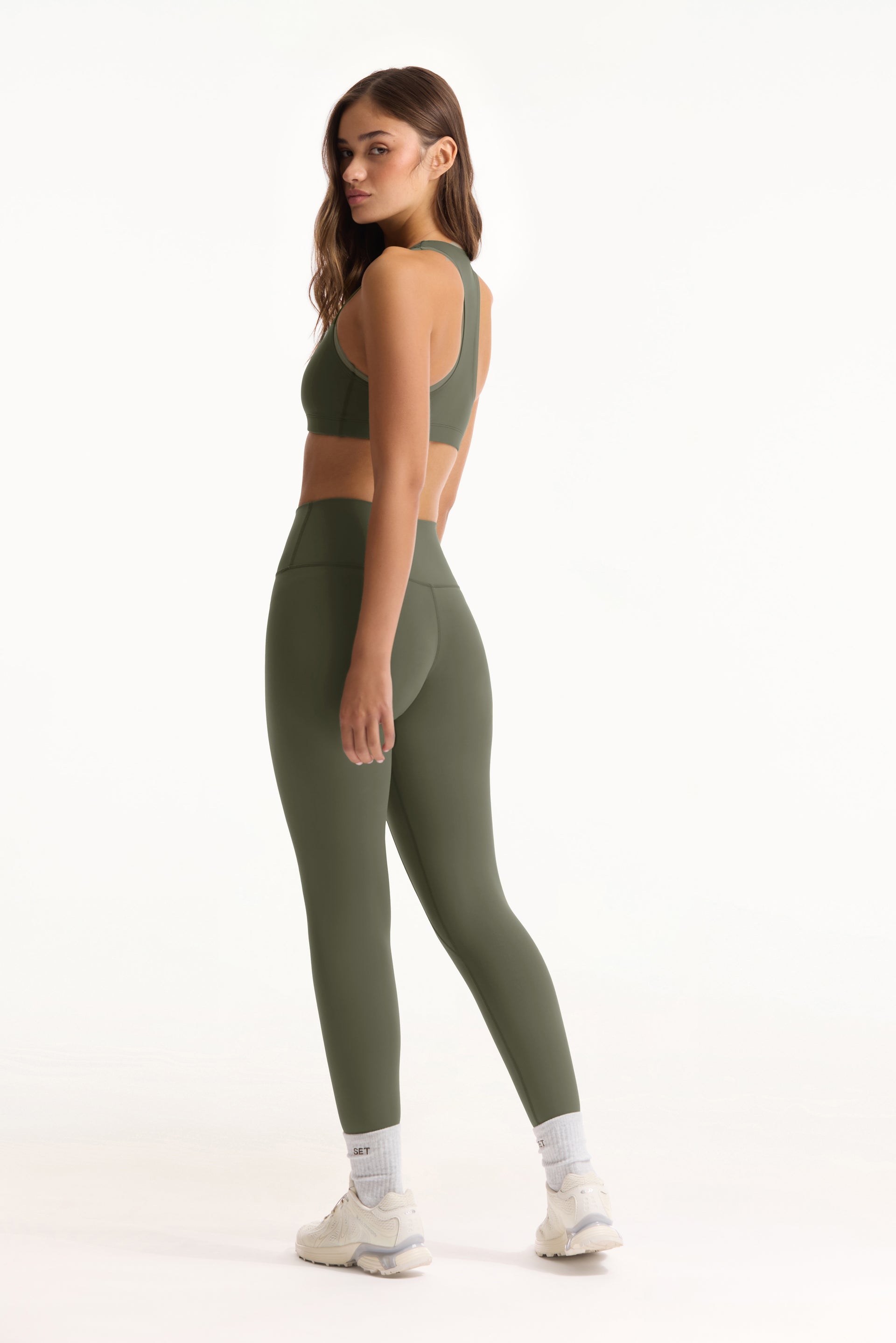 Woman wearing a green athletic outfit on a white background