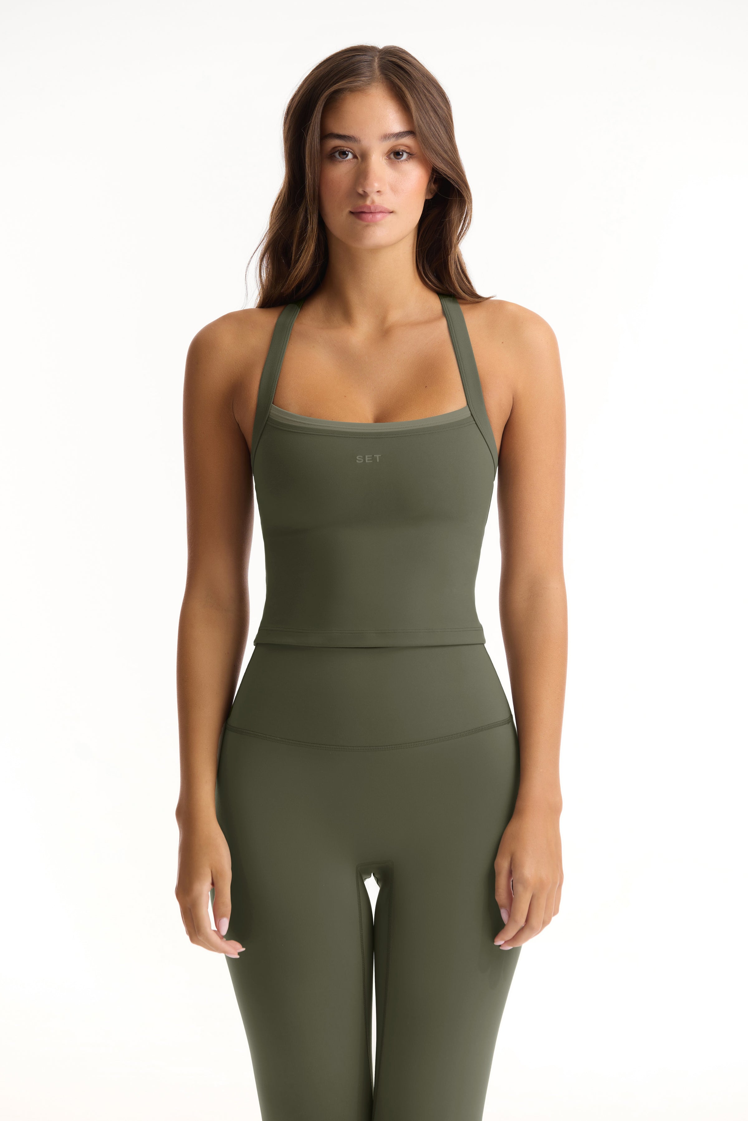 Woman wearing a green athletic outfit on a white background 