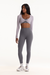 Woman wearing a white long-sleeve crop top and gray leggings on a white background