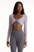 Woman wearing a gray athletic outfit with long sleeves and leggings on a white background <model-info>Autumn wears a size S and is 5’7½”, 25” waist, 32” bust.</model-info>