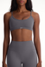 Woman wearing a gray sports bra and leggings set on a white background