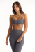 Woman wearing a gray sports bra and leggings set on a white background <model-info>Sophie wears a size S and is 5’9½”, 23” waist, 34CD bust.</model-info>