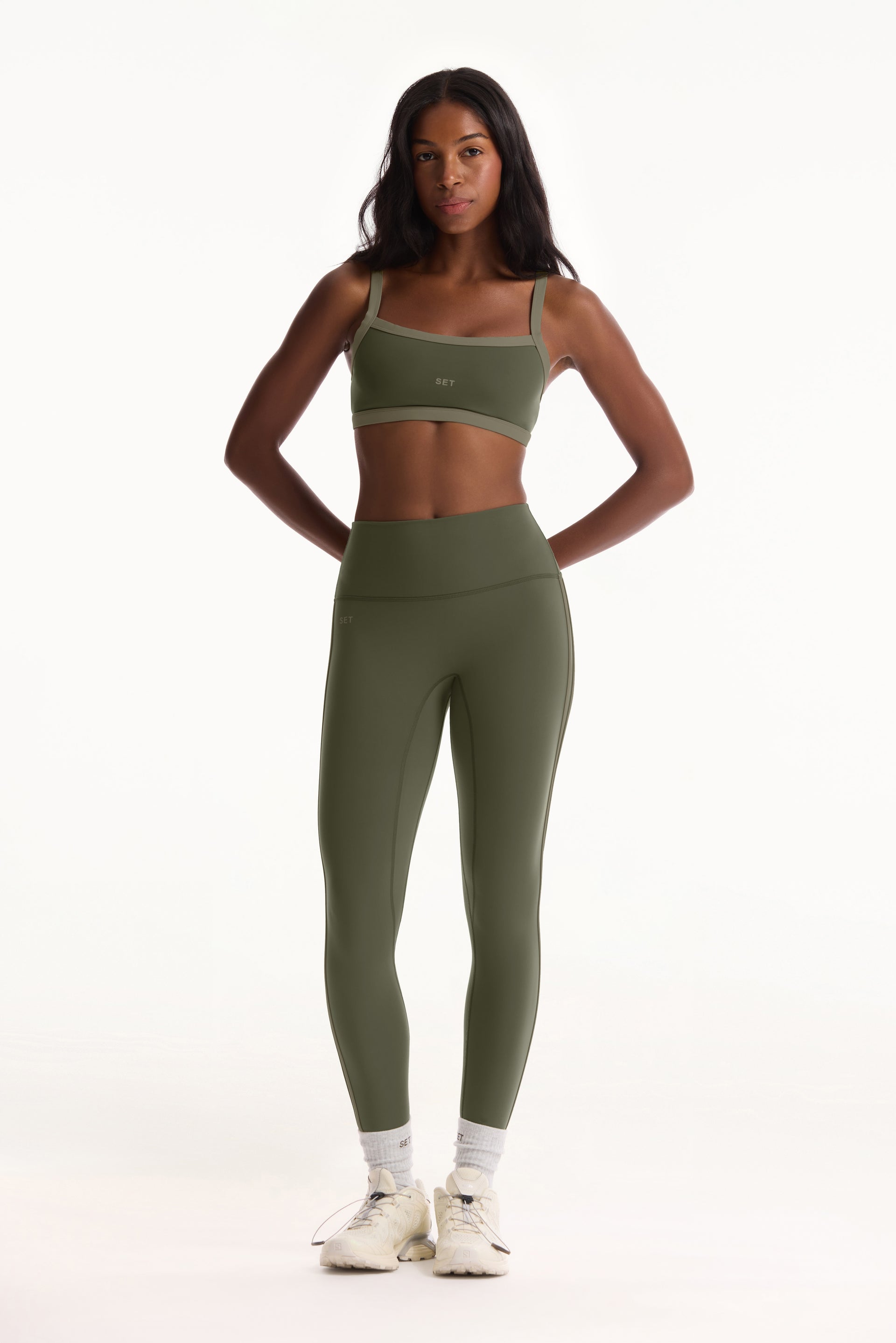 Woman wearing green athletic outfit on a white background