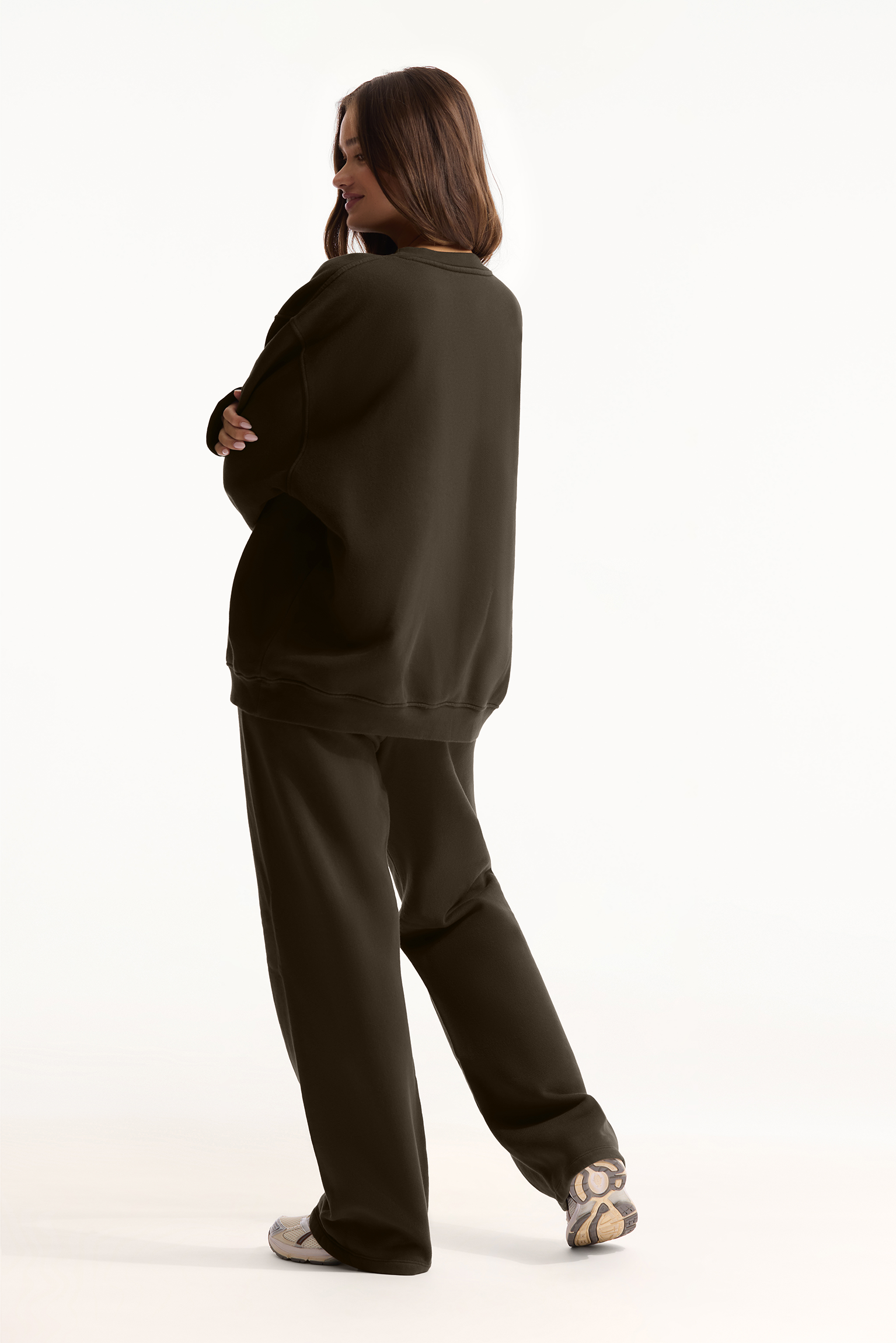 Person wearing a dark green tracksuit on a white background