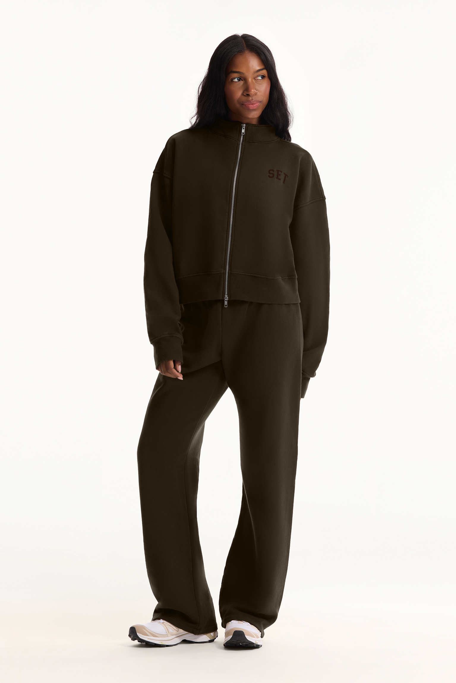 Person wearing a dark green tracksuit with 'G/FORE' branding on a white background