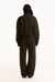 Person wearing a dark green tracksuit on a white background