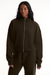 Person wearing a dark brown tracksuit with a brand logo on a white background <model-info>Autumn wears a size M and is 5’7½”, 25” waist, 32” bust.</model-info>