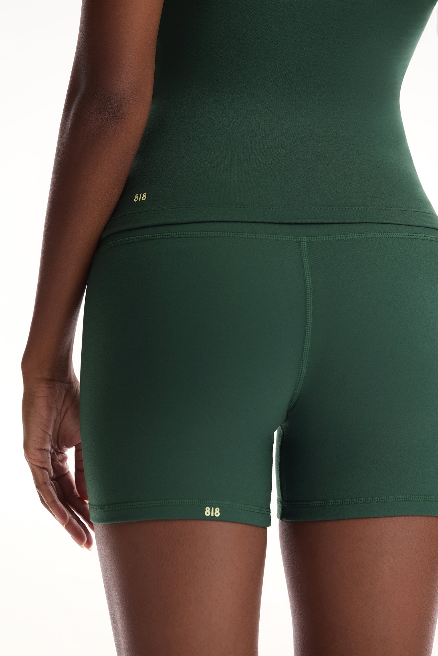 Green athletic shorts worn by a person on a white background