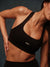 Person wearing a black sports bra with 'SET' branding against a dark background