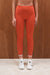 Person wearing bright orange leggings and white sneakers with red accents against a wooden background <model-info>Grace wears a size XS and is 5'8", 25" waist, 32" bust.</model-info>