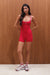 Woman wearing a red unitard against a wooden wall <model-info>Sydnee wears a size XS and is 5'8", 22” waist, 32BB bust.</model-info>