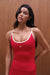 Woman wearing a red tank top with white straps against a wooden background <model-info>Sydnee wears a size XS and is 5'8", 22” waist, 32BB bust.</model-info>